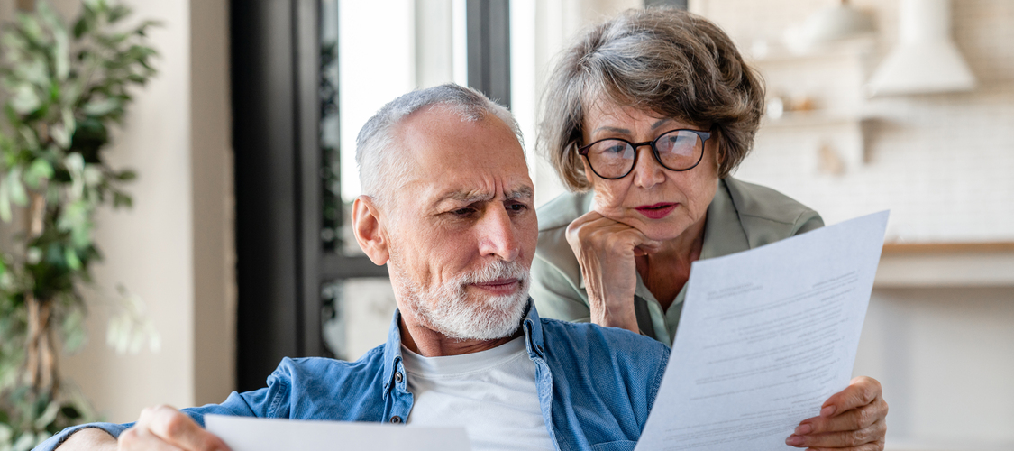 An older couple looking at paperwork together.