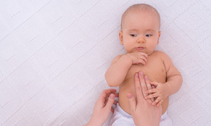 Dojenček uživa v mamičini masaži. Simbolna fotografija za članek Infrantilni spazmi