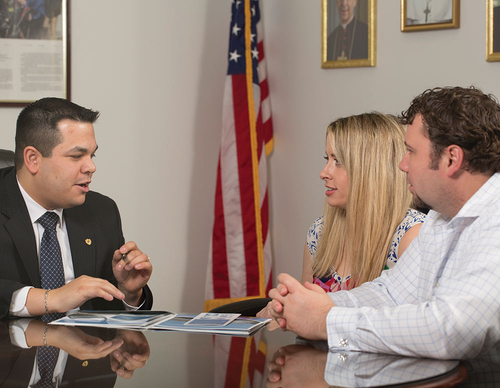 Henry Rangel, assistant general agent for Knights of Columbus councils in and around Houston, meets with a Knight and his wife.