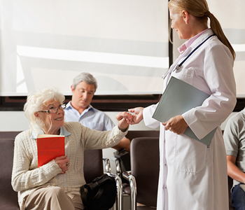 Zdravnica v čakalnici, polni pacientov - ko se naročate na pregled, je dobro vedeti, kaj vam omogoča napotnica za zdravniški pregled in kje.