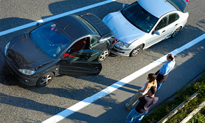 Vozniki vozil, udeleženih v prometno nesrečo, stojijo ob avtocesti in čakajo na pomoč.
