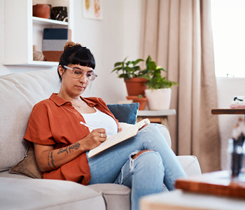 Mlajša ćenska v udobju svoje dnevne sobe pripravlja osnutek svoje prve oporoke