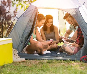 Druščina mladih je kampiranje popestrila z igranjem družabnih iger v šotoru.