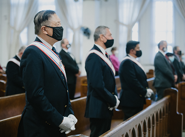 Forth degree Knights standing in a pew at church wearing maskks during the pandemic.