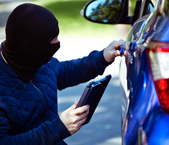 Lopov poskuša vdreti v parkiran avto - Simbolna slika o zavarovanju avta pred krajo