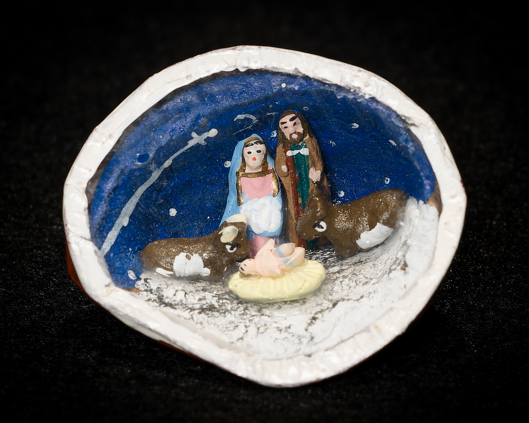 Image of Nativity scene featuring the Holy Family, donkey, and ox contained within a walnut shell.