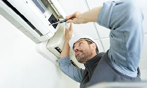 Monter klimatske naprave med namestitvijo notranje enote na steno dnevne sobe.