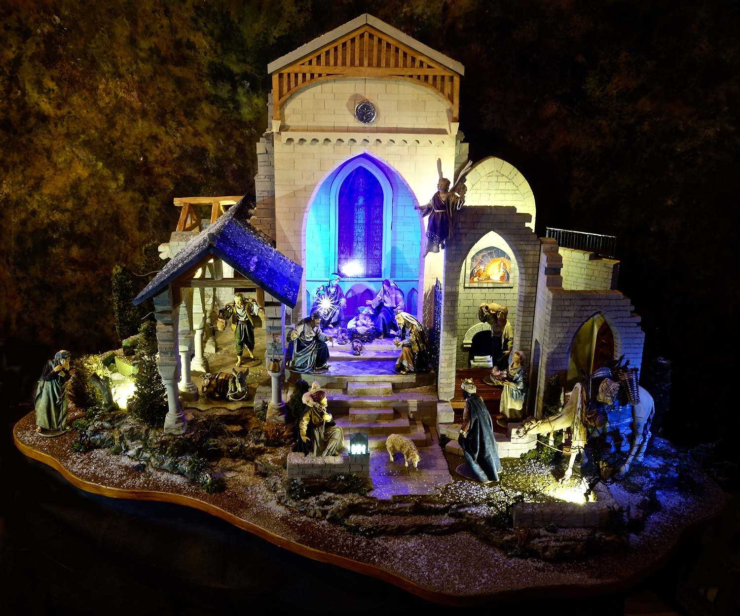 Nativity scene placed with a structure inspired by Gothic and Romanesque architecture. 