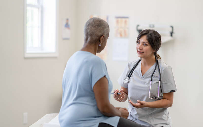 woman in an exam room during patient appointment with her doctor