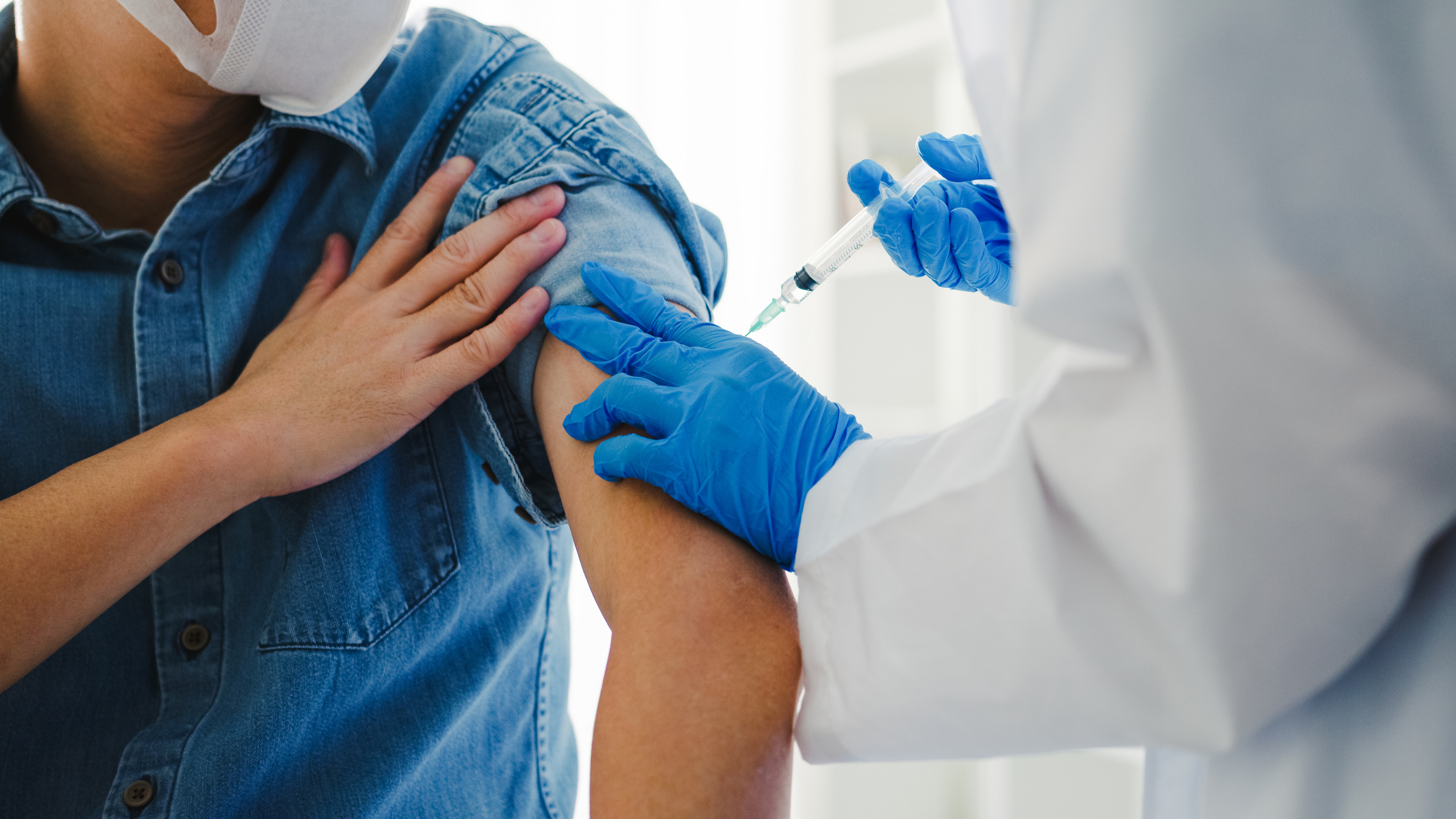 image of medical provider holding a syringe to a patient's arm