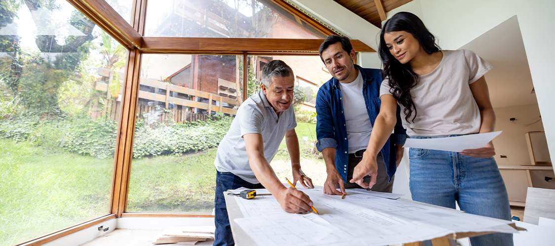 Family drawing blueprints with a contractor