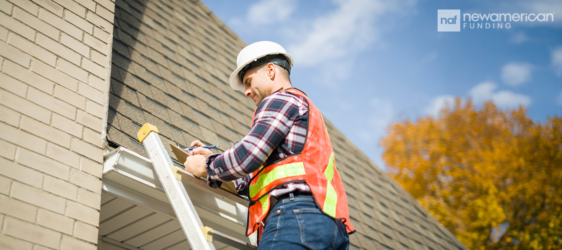 A man on a ladder checking a roof.