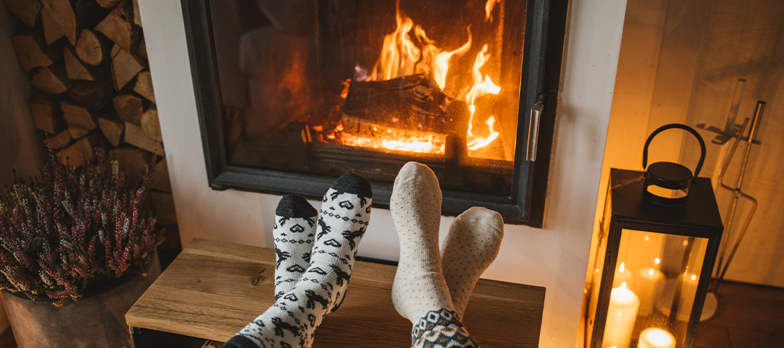 Feet propped up by a warm fireplace