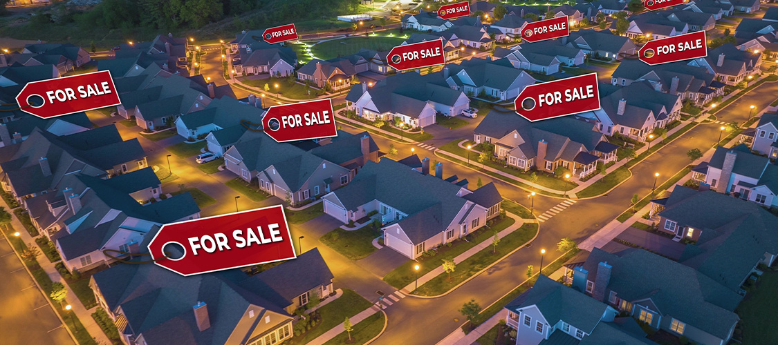 An aerial view of a neighborhood with for sale signs on many of the houses