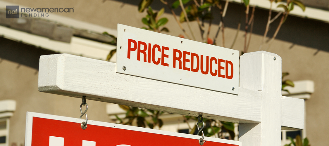 A price reduced sign on top of a for sale sign.