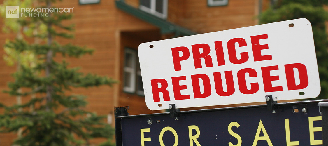 A price reduced sign over a for sale sign.