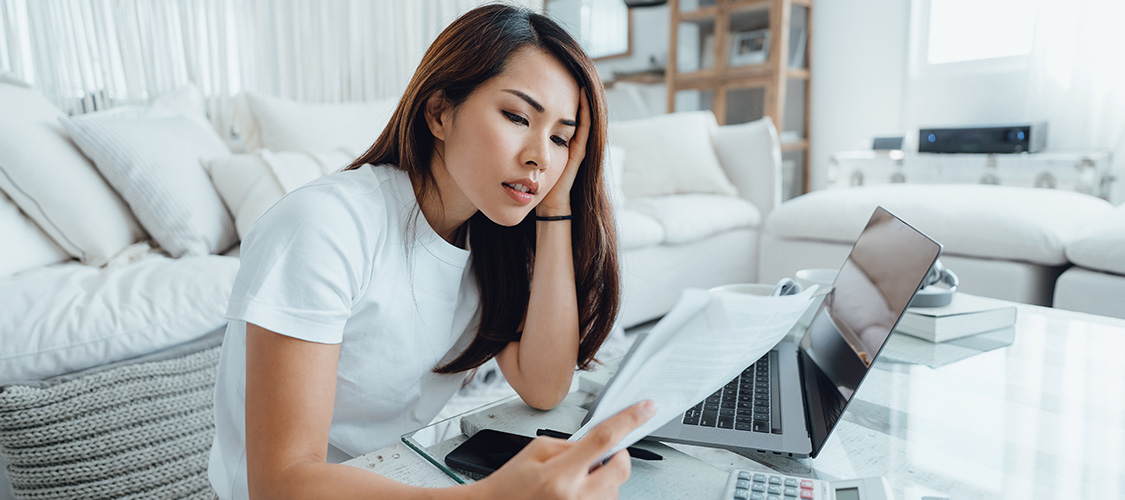 A woman sitting down holding up paperwork.