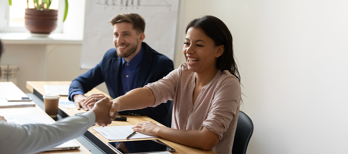 Couple shaking hands in a business meeting