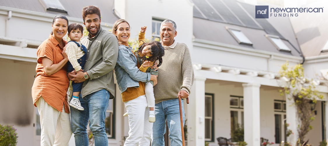 A large, multi-generational family standing in front of a house.