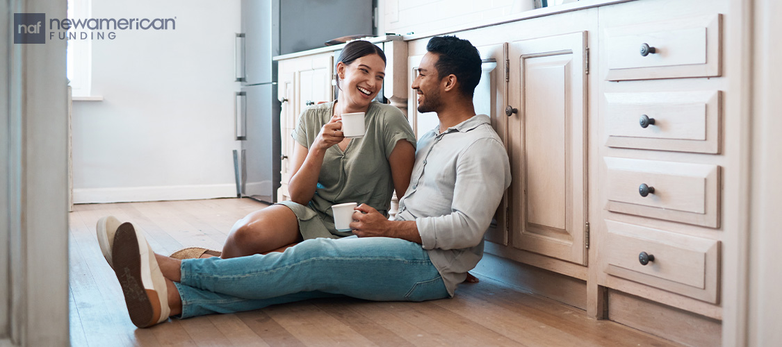 A couple sitting on the floor talking. 