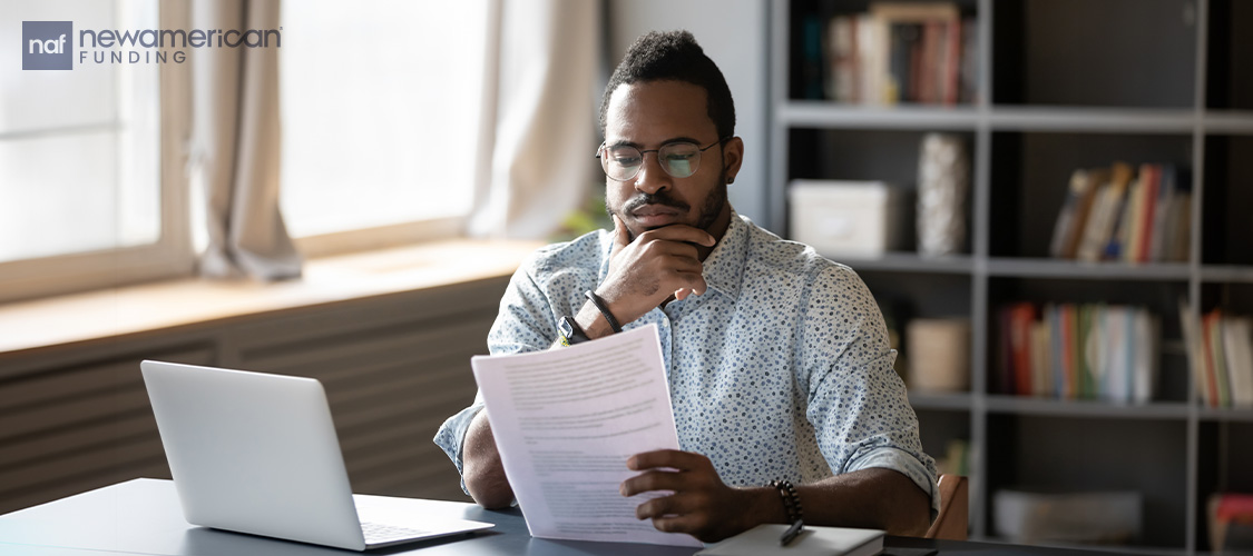 Someone looking at paperwork critically.