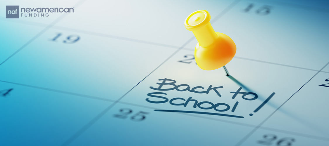 A calendar with 'Back to School' written in one of the days with a pushpin in it.