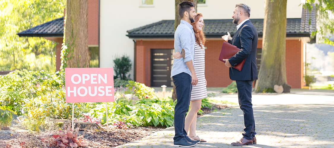 Couple speaking with a Real Estate Agent