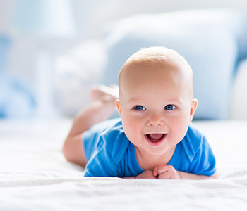 Dojenček na sliki pase kravice in se prešerno smeji v kamero. Dojenčki imajo še veliko časa za razvoj možganov.