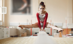 Mlada gimnastičarka izvaja vajo na bradlji, po tem, ko je okrevala po poškodbi kolena.