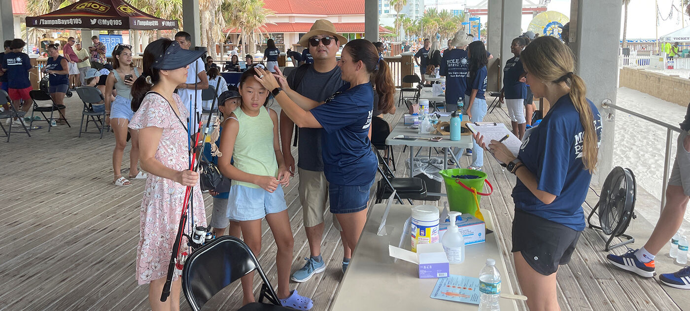 A family gets screened for skin cancer at Pier 60 in 2023.