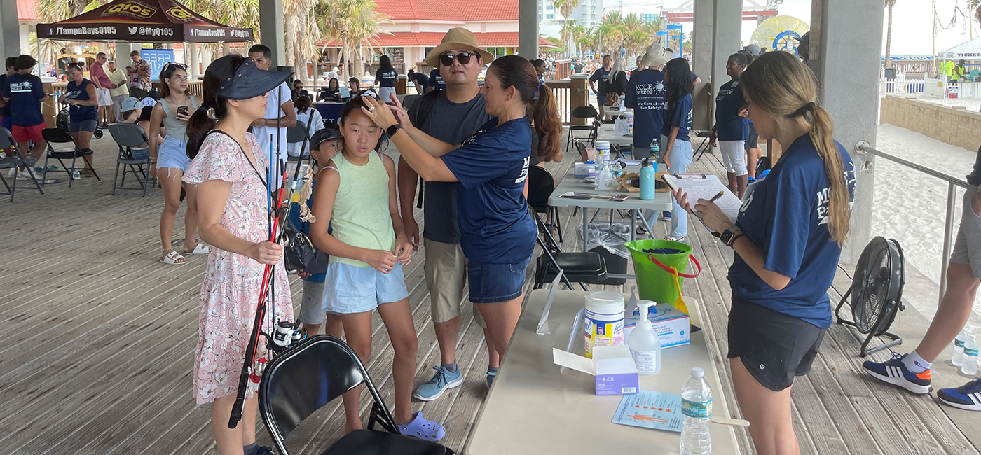 A family gets screened for skin cancer at Pier 60 in 2023.