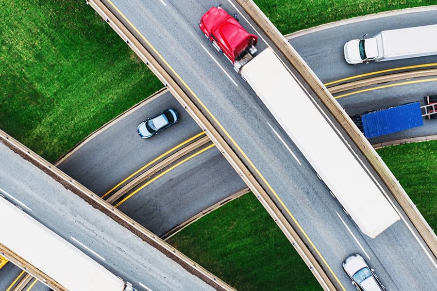 smart-fleet-dispatch-chapter1-900x600.jpg Aerial view of an intersection with trucks on it.