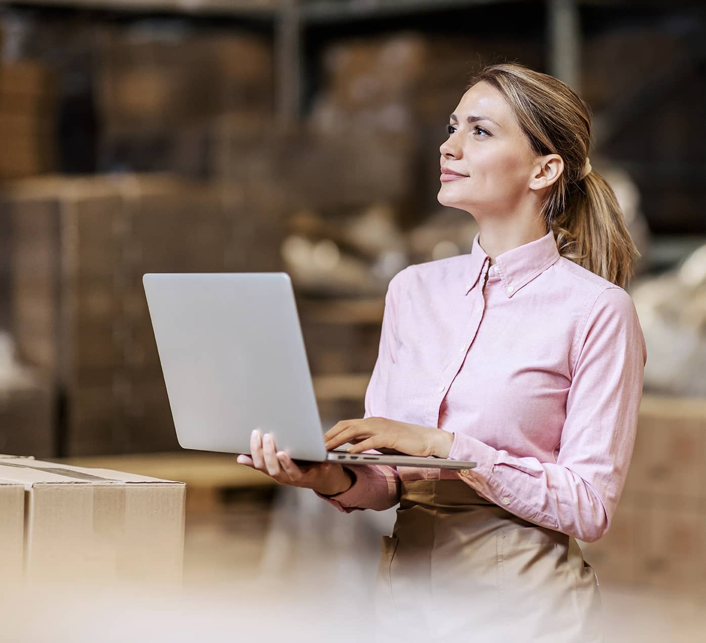 Female looking at a laptop in a warehouse
