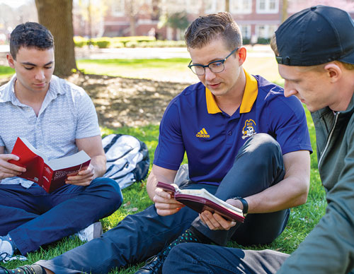 Duke Bednarke, a Knight of Columbus and a FOCUS missionary at East Carolina University, reads Scripture with students on campus in Greenville, N.C. (Photo by Eric Jones)