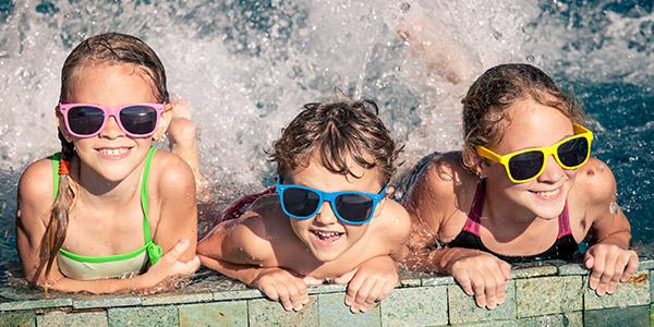 happy kids with colorful sunglasses enjoying the pool