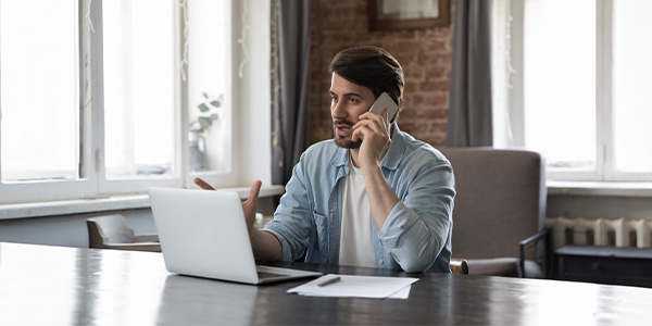 man on phone with laptop