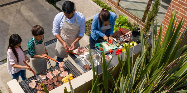 family cooking in outdoor kitchen