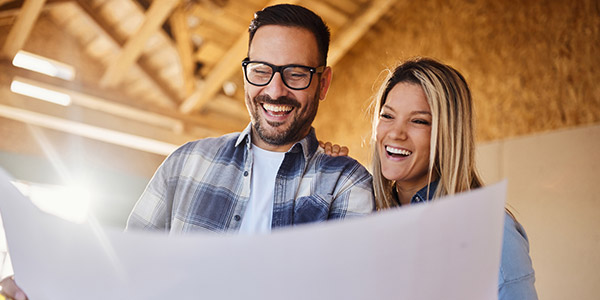 happy couple looking at their house plan