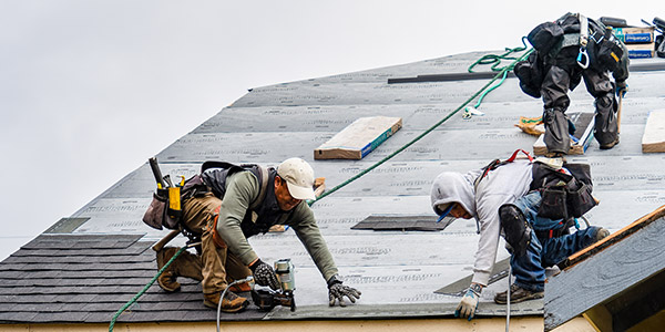 roofers laying down a new roof