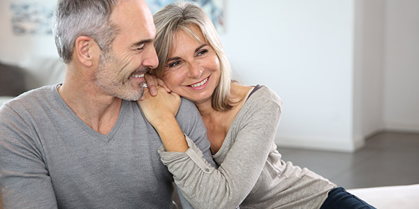 An older white man and white woman sit smiling together