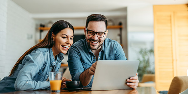 smiling couple looking at a laptop together