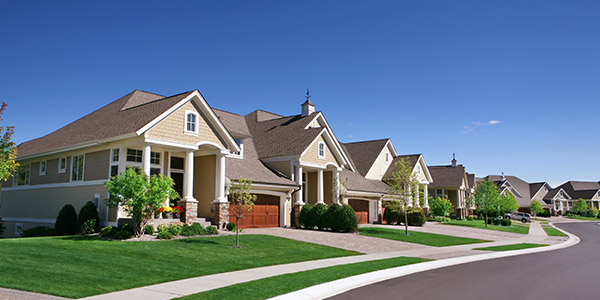 A line of beige homes along a road in a neighborhood