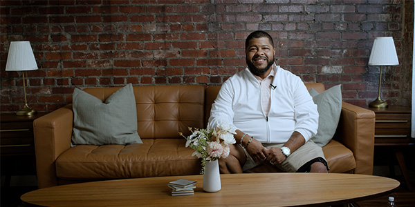 New American Funding loan officer Ken Smith sitting on a couch.