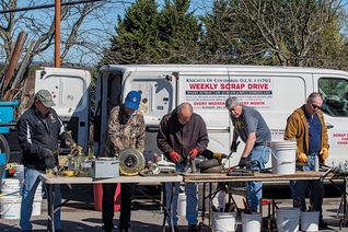 Grand Knights Bill Traube (second from right) and other Knights sort items containing metal donated during a collection at Holy Family Parish in Middletown, Md. (Photo by Matthew Barrick)