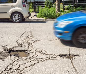 Udarne jame na cesti lahko neprevidnemu vozniku povzročijo velike preglavice in visok račun za serviserja.