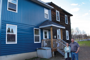 Marc and Carole Jobin stand with Marie-Ange in their new home addition, built with help from Marc’s brother Knights. (Photo by Kenton E. Biffert)