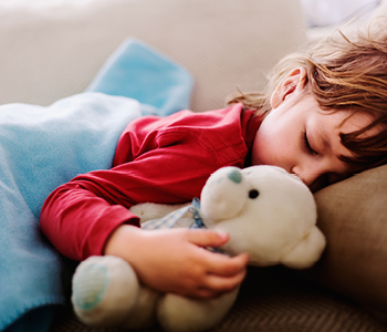 Vročinski krči pri dečku so minili – kljub vročini spi v postelji.