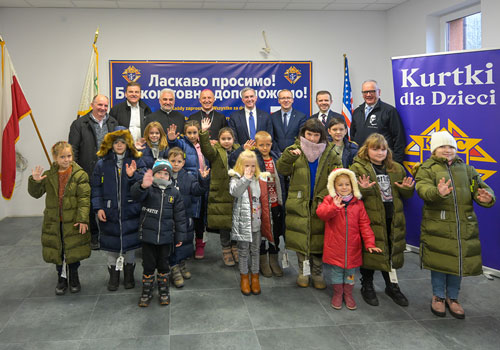 Knights of Columbus leaders, Bishop Marek Solarczyk of Radom, Poland, and Father Wiesław Lenartowicz, pastor of Our Lady of Częstochowa Parish, stand with refugee children served by the new Blessed Michael McGivney House in Radom. Photo by Tamino Petelin&scaron;ek