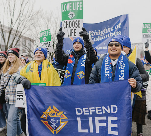 College Knights walk toward the Supreme Court building with thousands of other marchers on Jan. 21, 2022.