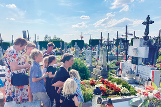 Kelly Lindquist and her children pray at the grave site of the Ulma family.